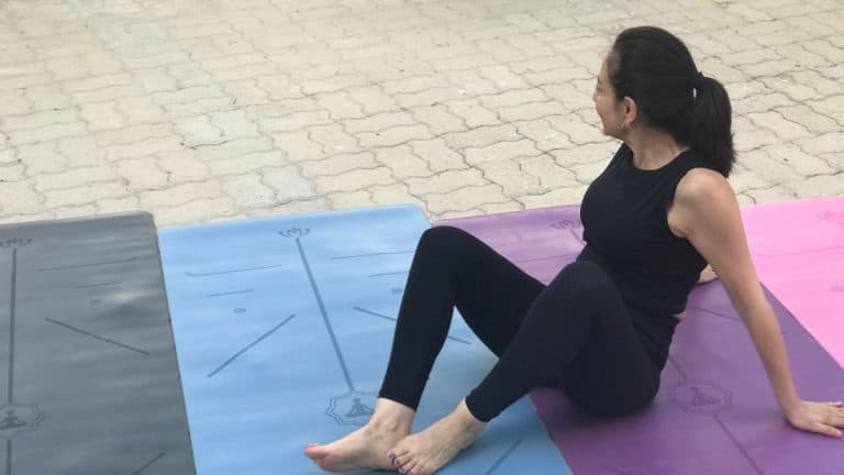This photo shows a yoga sitting on different colors of best grip yoga mats
